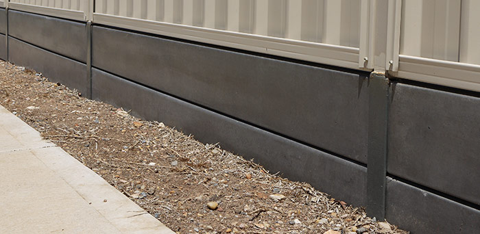 Concrete under-fence plinth installation